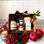 The Grand Ritual luxury gift set displayed decoratively in a box — includes lavender rosemary cream, citrus CBD cream, charcoal face scrub, face oil, body soaps, and grapefruit lemongrass candle for a restorative self-care experience.