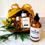 Skin Deep gift set displayed decoratively with body cream, soap bar, charcoal face scrub, and face oil — a complete skincare ritual for exfoliating, hydrating, and restoring skin.